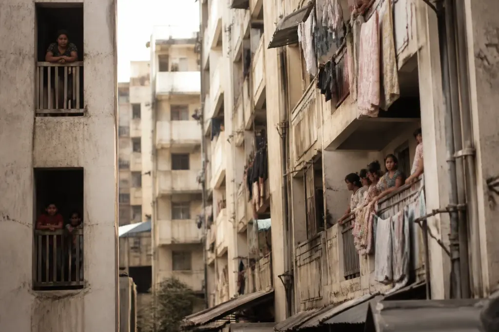 Immeubles collectifs serrés avec nombreux habitants visibles aux balcons