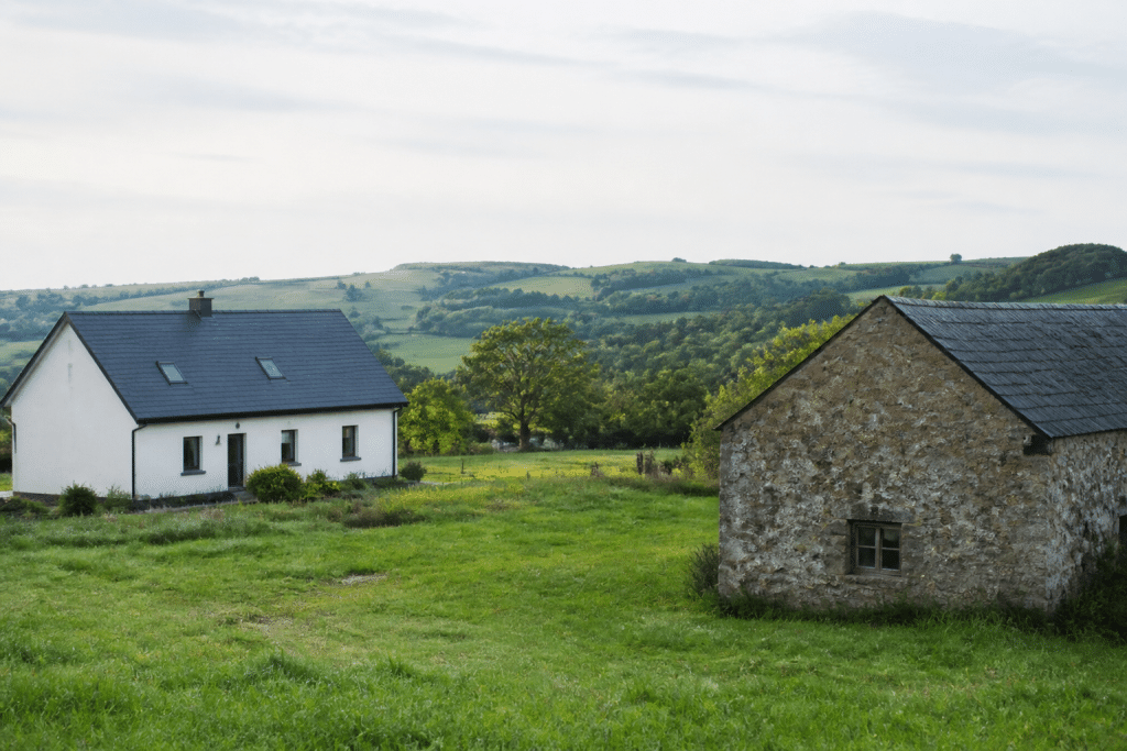 Maisons espacées avec champs verts en arrière-plan