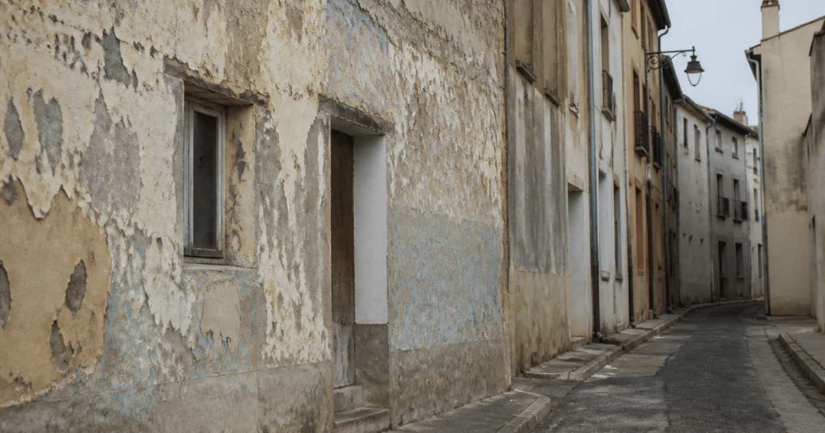 Rue degradee de Frontignan avec batiments delabres et murs peeles