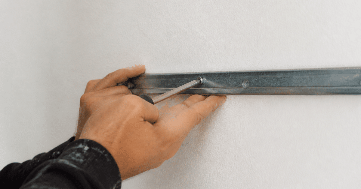 Mains vissant support metal horizontal sur mur blanc
