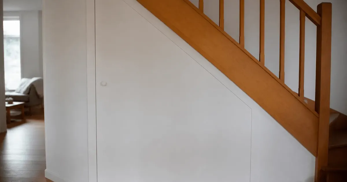 Porte blanche fermee integree sous escalier en bois
