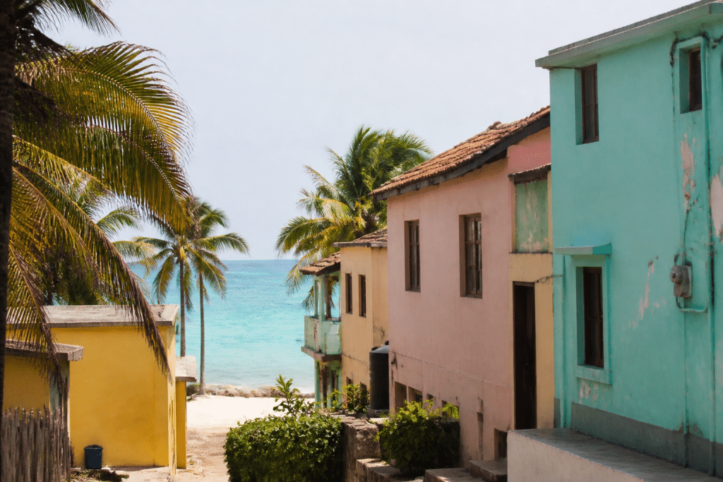 Maisons colorees pres plage avec palmiers et mer bleu clair