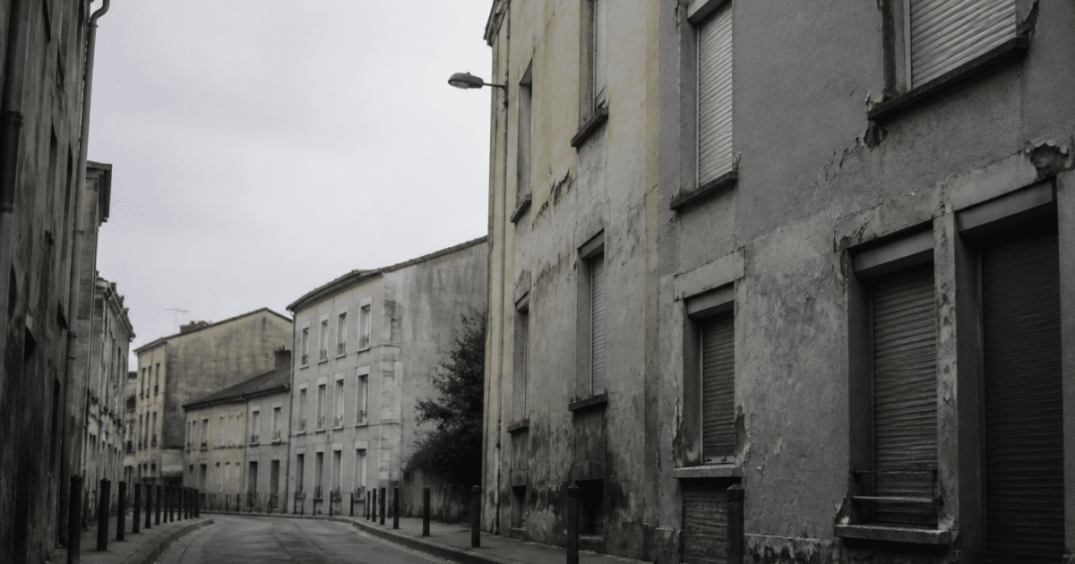 Rue deserete de Cachan avec immeubles delabres et facades grises
