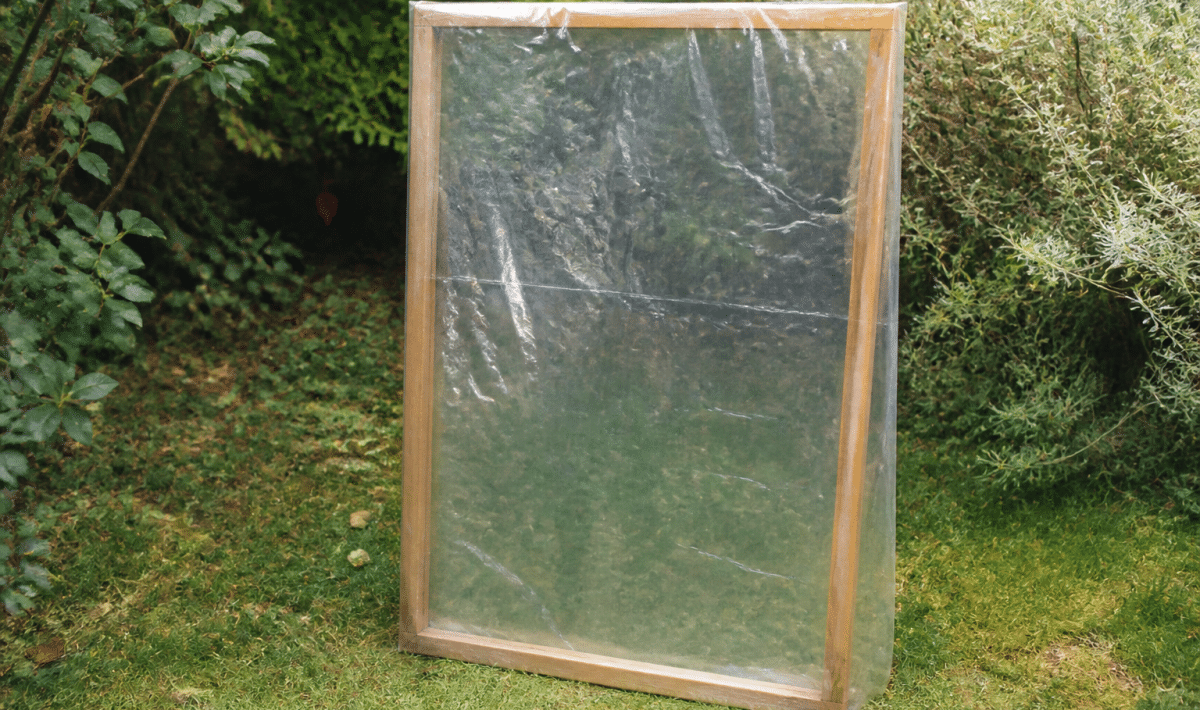 Cadre bois transparent recouvert plastique transparent debout jardin